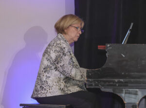 a woman playing the piano at the gala